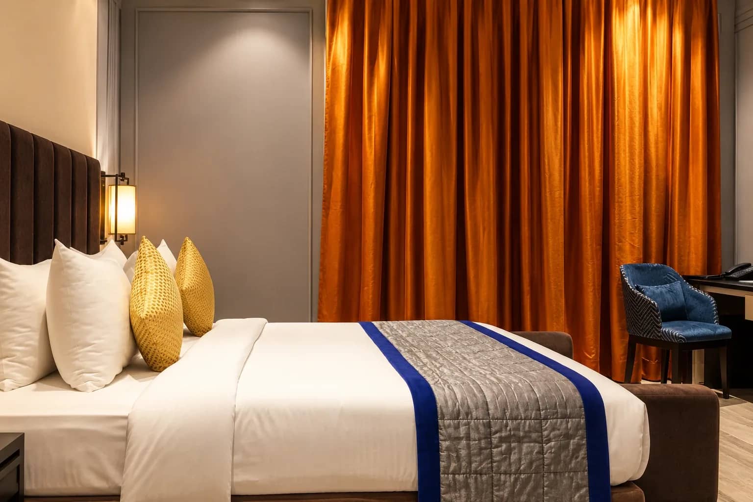 Bed, bronze drapes and writing desk in the Luxury Suite
