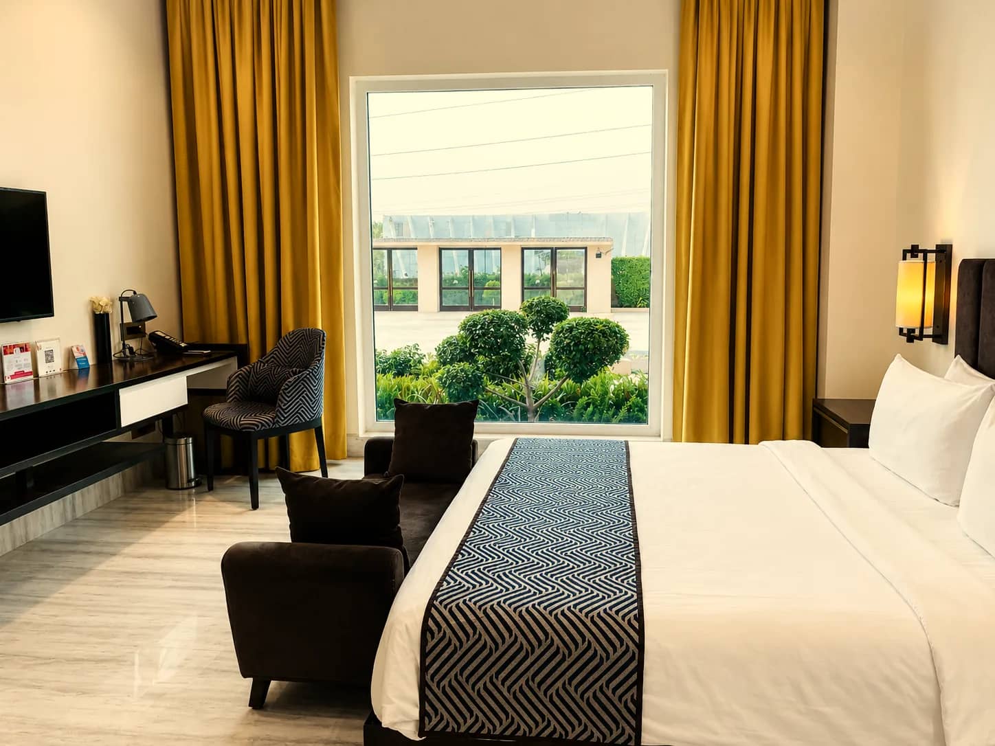Junior Suite bedroom with a picture window onto the gardens