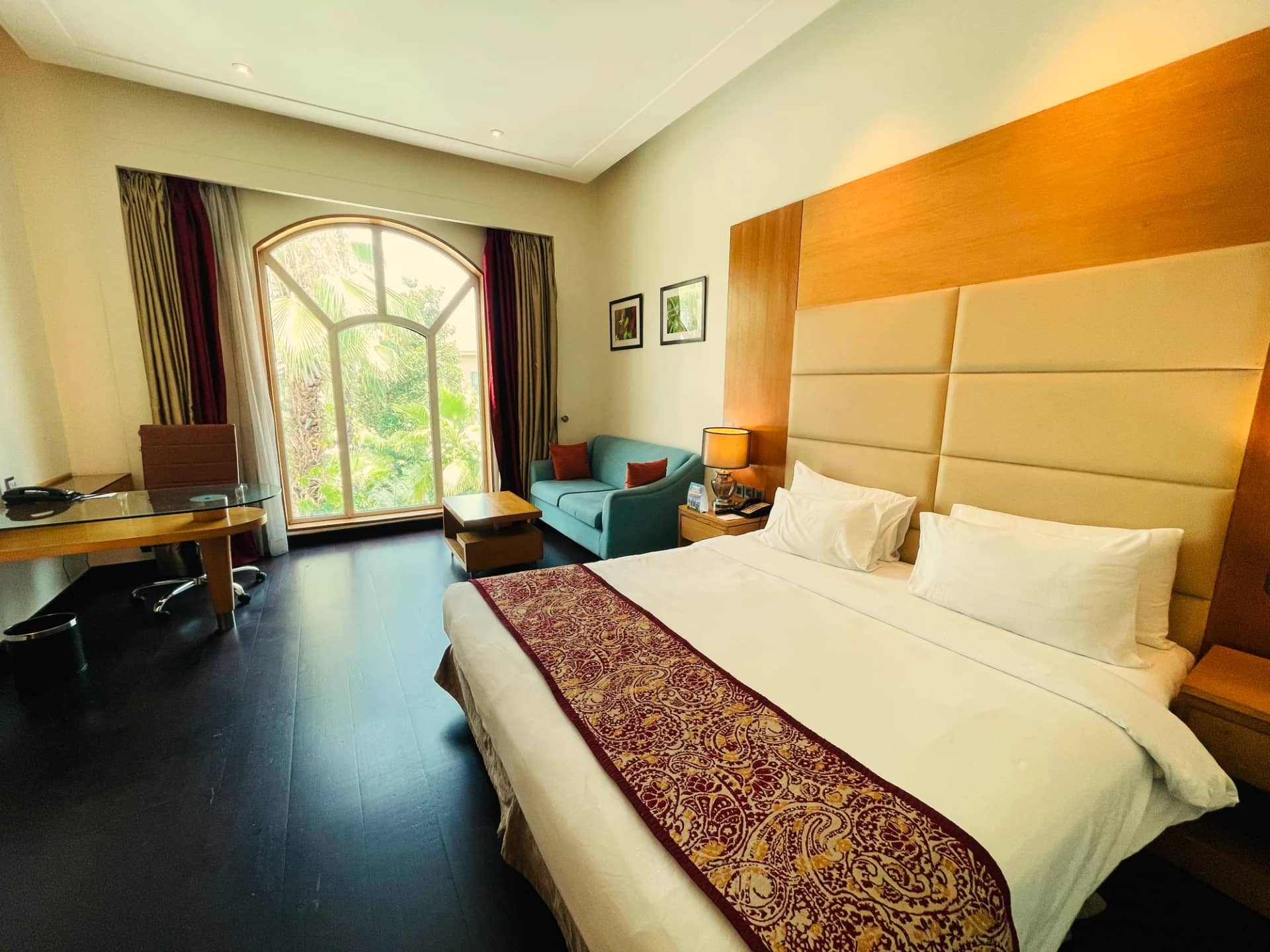 Premium Room with a king bed and an arched window to the gardens
